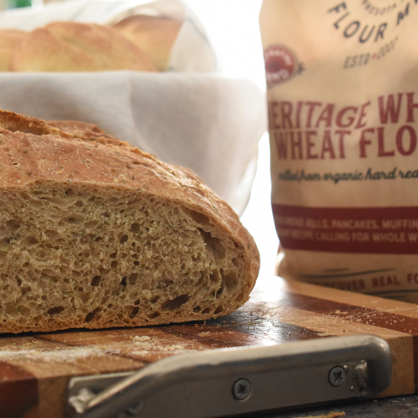 whole wheat flour with a loaf of whole wheat bread