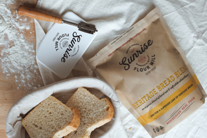 White bread in a bowl on a table with a bag of heritage bread flour